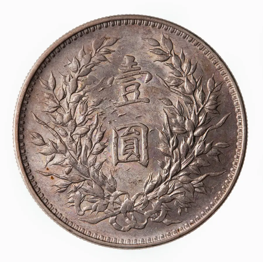同じ銀貨の裏面。二本の稲穂に囲まれた「壹圓」の文字